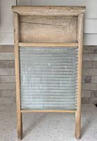 Front view of antique wooden washboard with pressed glass panel