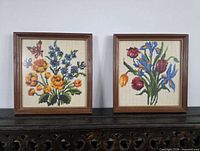 Both framed cross-stitch pieces side by side