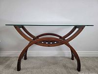 Front view of console table showing glass top and arched wood base