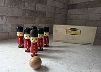 Six painted wooden guard skittles, wooden ball, original box visible