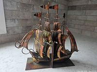 Full view of assembled galleon ship bookends showing patinated copper sails and brass details