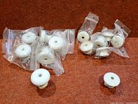 All 13 porcelain cabinet knobs bagged and two displayed for scale