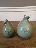 Front view of both vases showing size difference and crane motif on larger vase