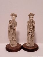 Front view of both carved figures on bases