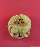 Front view of round jade pendant showing horse carving