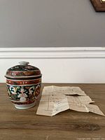 Jar with lid next to folded receipt on tabletop
