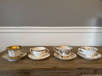 Four tea cup and saucer sets aligned