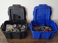 Two storage bins, lids open showing assorted K'NEX pieces