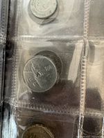 Close-up of two coins in binder page pockets