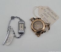 Both wristwatches front view with identifying tags