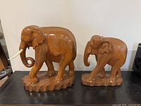 Both mahogany elephant sculptures side by side