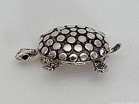 Top view of sterling silver turtle brooch showing shell pattern and limb details