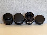 Four lenses lined up front view on neutral background