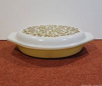Side profile of casserole with lid fitted, showing olive base and full lid