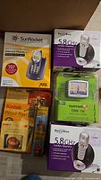Group shot of boxed phone sets, GPS unit, Kodak picture paper