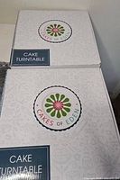 Two boxed Cakes Of Eden cake turntables showing brand and product name