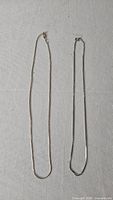 Full view of both sterling silver chains laid flat