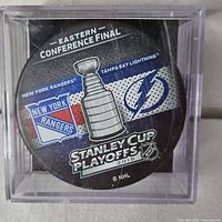 Front view of puck showing team logos and Stanley Cup Playoffs 2015 graphic