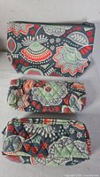 Front view of three Vera Bradley Nomadic Floral pouches