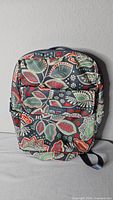 Front view of Vera Bradley paisley backpack showing full pattern and zip front pocket