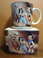 Mug side showing Geppetto, Pinocchio, Figaro and Cleo, mug on top of box