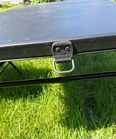 Pull-latch on folded black plastic table edge