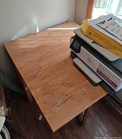 Top view of light wood Ikea drop-leaf table with one leaf extended