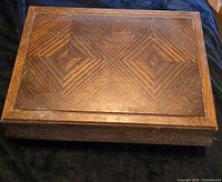 Closed wooden jewelry box showing exterior wood grain pattern and wear