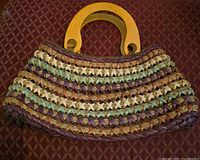 Front view showing multicolor raffia weave and wood handles