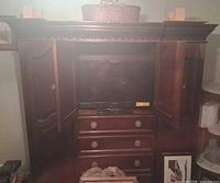 Front view showing open central doors, TV compartment, and drawers