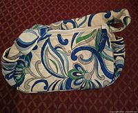 Front view of quilted floral swirl crossbody bag showing pattern and shape