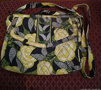 Front view of quilted cotton yellow floral Vera Bradley bag showing pattern and front zip pocket