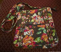 Front view of quilted floral bag showing exterior pattern, strap, zipper pocket