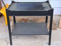 Front view of black two-tier side table showing overall structure and shelf