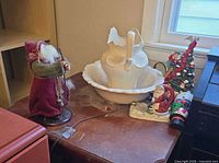 Overall view of table top with pitcher, basin, figurines