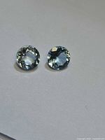 Pair of round pale blue aquamarines on neutral background