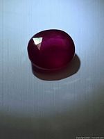 Top view of oval ruby gemstone showing color and facets