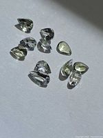 Group of nine pear-cut lemon-lime tanzanite stones on white background