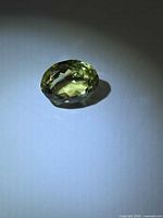 Oval faceted lemon citrine side view under lighting