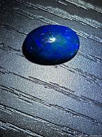 Top view of the opal showing blue body color and green flashes