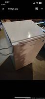 Exterior view of white compact refrigerator showing front, top and power cord