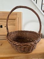 Full view of woven wicker basket showing handle and weave detail