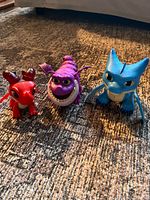 Three dragon toy figures arranged on carpet