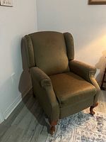Recliner chair in upright position showing upholstery and legs