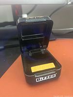 Open Bitzee device showing interior pad and exterior branding