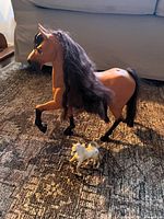 Large brown Spirit horse and small foal on rug