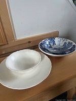 Stacked white Italian plate and bowl beside two blue Ridgway ironstone bowls