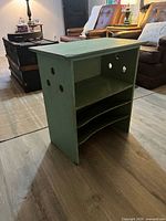 Overall view of green wooden paper storage unit showing shelves and compartments