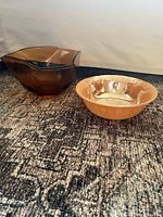 Amber glass bowl and peach lustreware bowl side by side