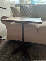 Front view of wooden pedestal side table showing overall design